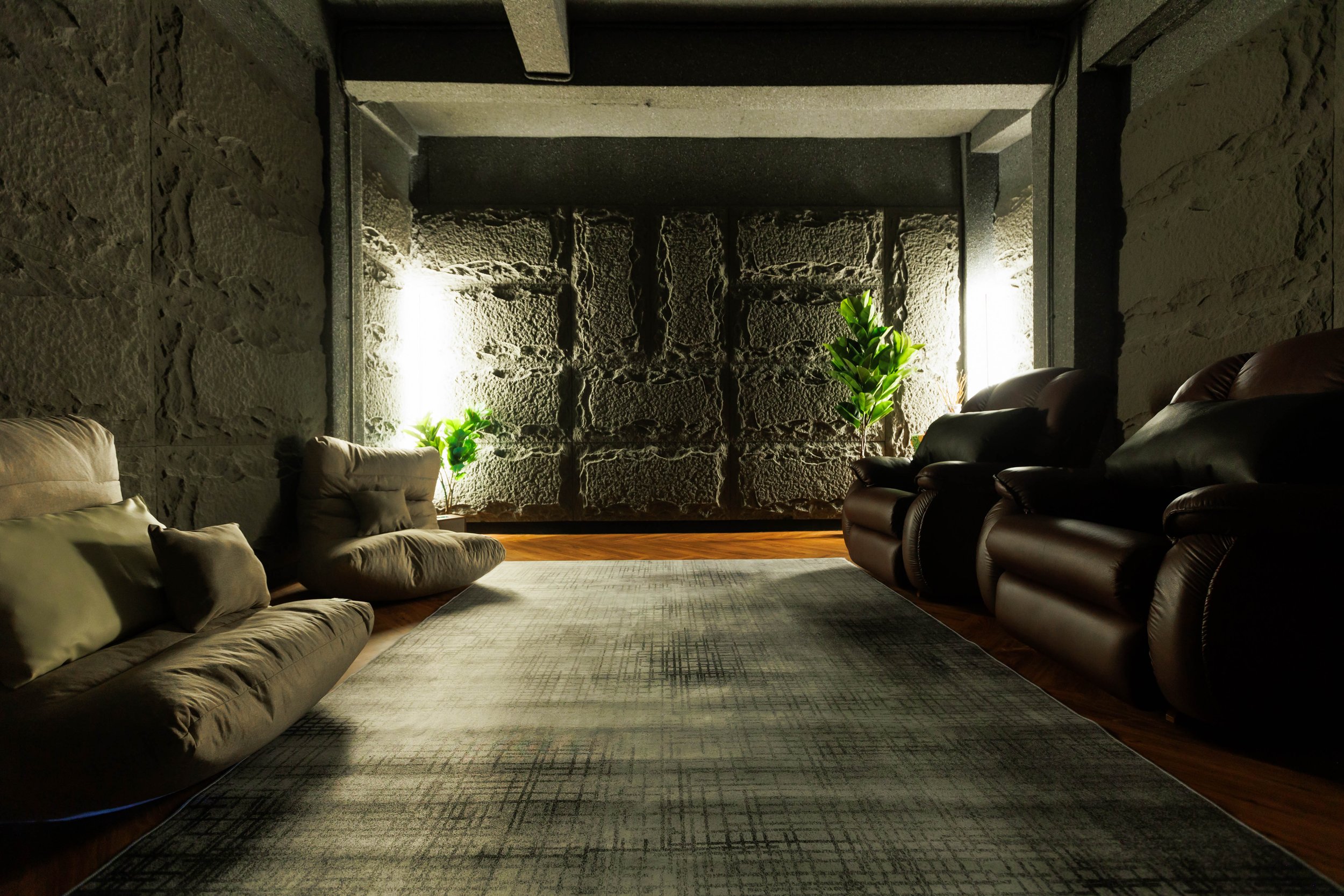 Dim mindfulness lounge with recliners and stone walls at Maxwell Onsen Bangkok