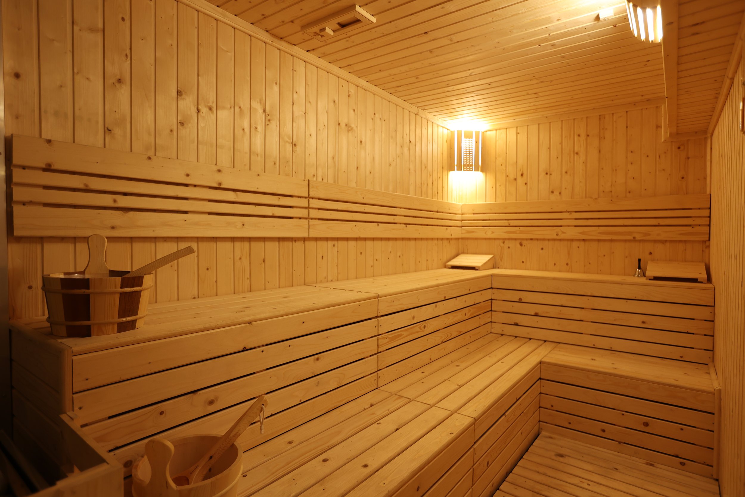 Pine-clad sauna with tiered benches and wooden buckets at Maxwell Onsen Bangkok